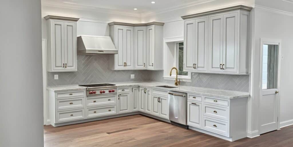 Chesterfield kitchen design idea showing L shape kitchen with extra tall wall cabinets, pro style range-top and stainless steel hood.