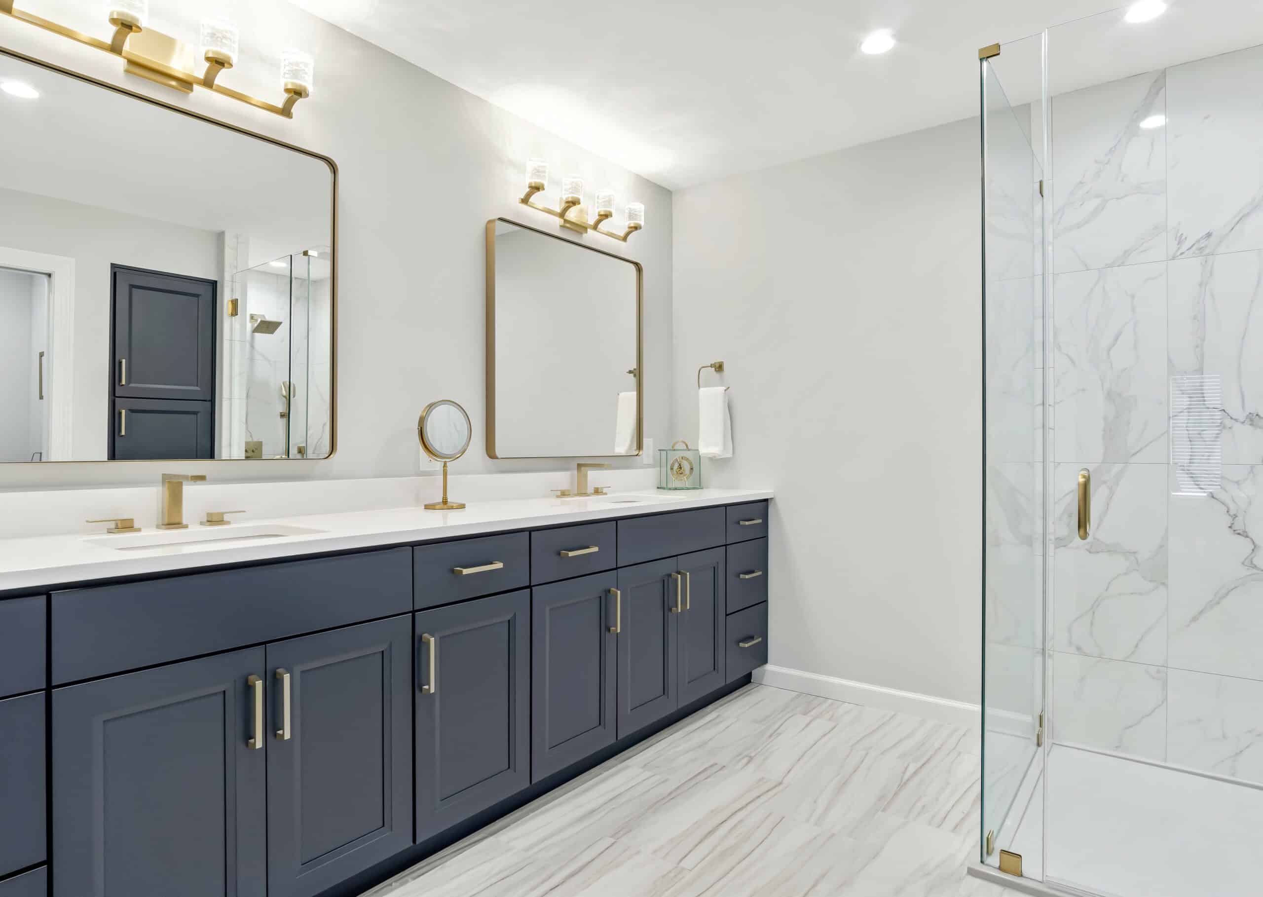 Navy blue master bathroom cabinets with gold mirrors and plumbing fixtures in St Louis, MO by Thompson Price