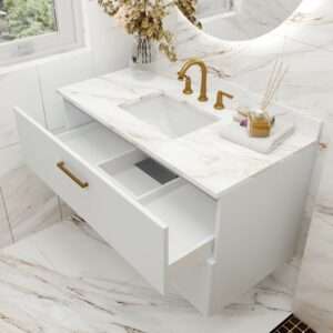 Floating vanity cabinet in Aria flat style drawers with Blanc white finish and marble top with gold two handle lavatory faucet.