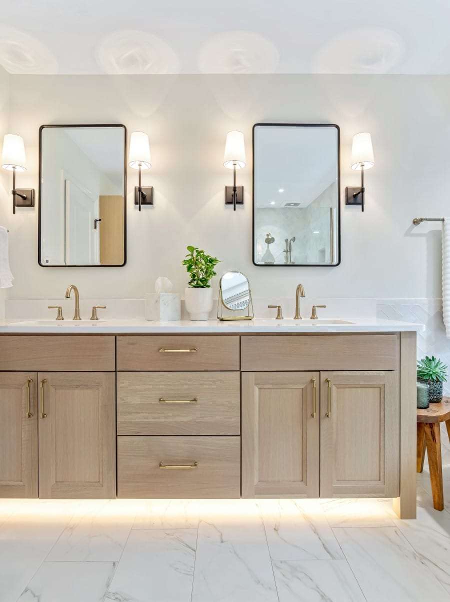 Master bathroom vanity cabinet in custom natural stained finish with satin brass plumbing fixtures.