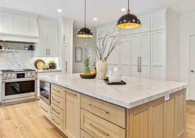 Kitchen remodel with custom white cabinets and quarter sawn white oak island cabinets with quartzite countertops.