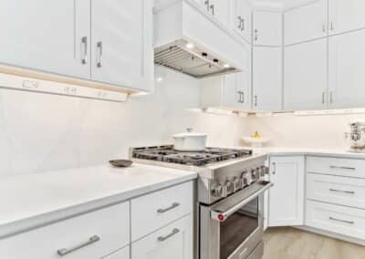 White custom kitchen remodel in St Louis, MO with 36" range and wood hood.