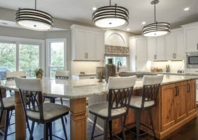 Kitchen remodel with white custom cabinets on all walls and medium stained custom island cabinetry.