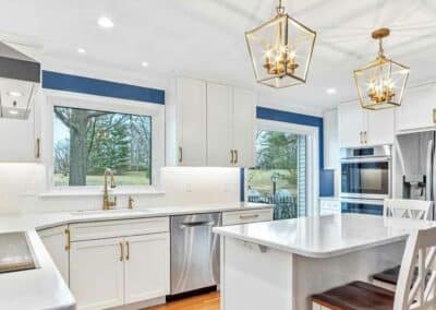 Large kitchen remodel with white cabinets, white quartz countertops and blue accent paint on the walls.