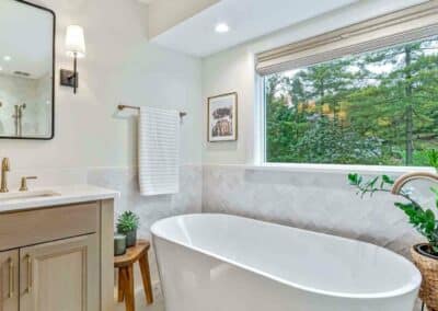 Master bathroom remodel with freestanding tub and wall tile around room.