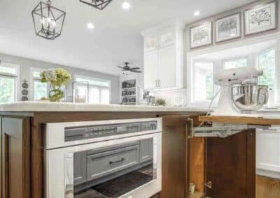 Luxury kitchen remodel showing custom cabinets with pop-up mixer shelf and built-in microwave drawer.