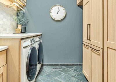 Custom laundry room remodel with custom stained quarter-sawn white oak cabinets and porcelain tile floor.