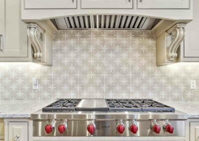 Kitchen remodel in St Louis, MO showing Wolf professional style cook-top under custom wood hood with corbels.