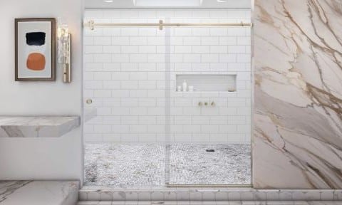 Bathroom remodel with custom heavy glass sliding shower door in barn door with satin brass finish.