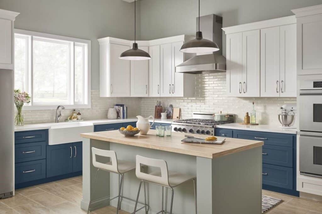 Kitchen and bathroom design trends 2025 - bold color in a kitchen with dark blue base cabinets and a sage colored island