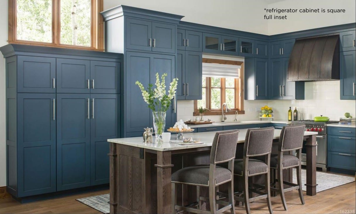 Custom perimeter kitchen cabinets in painted navy with dark stained kitchen island featuring full kitchen cabinet overlay