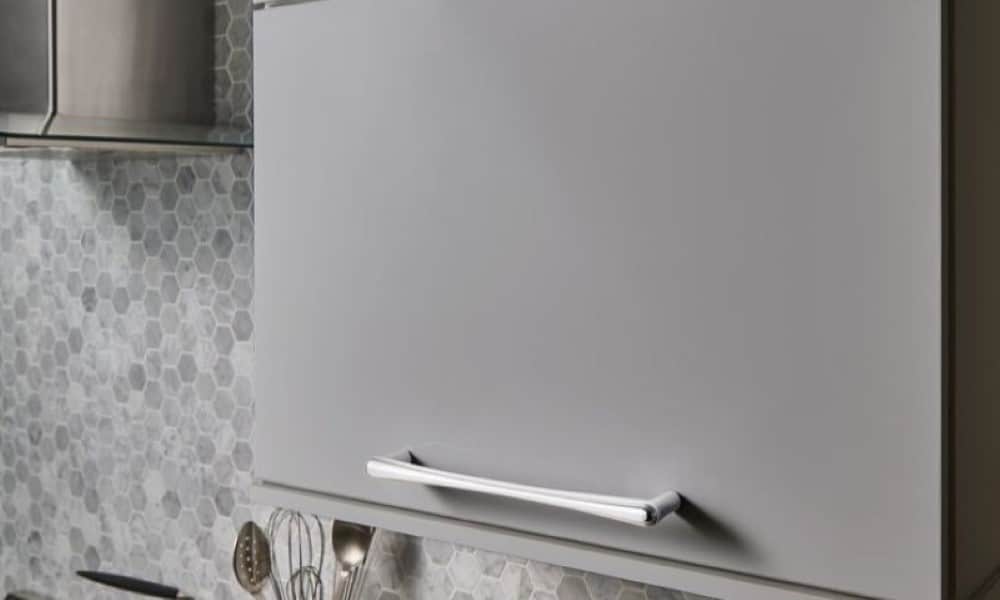 large cabinet hardware pulls in polished chrome installed horizontally on a lift up cabinet door in painted gray finish